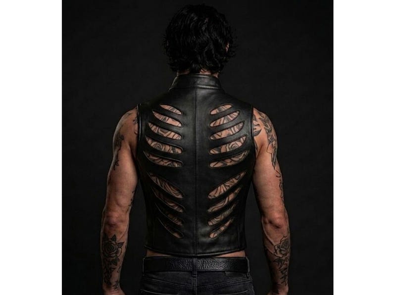 May include: A black leather vest featuring a series of horizontal cutouts across the back panel that resemble a rib cage structure. The garment has a high collar and a fitted silhouette, showcasing a smooth texture and clean, stitched seams.