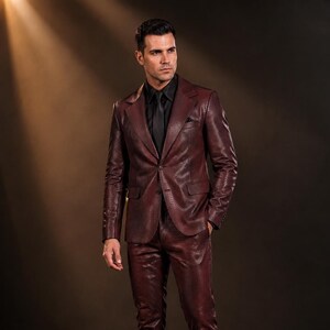 May include: A deep burgundy suit with a textured snakeskin pattern, featuring a single-breasted blazer with notched lapels and matching trousers. The suit is paired with a solid black button-down shirt, a black necktie, and black dress shoes.