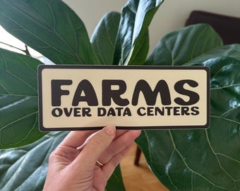 Puede incluir: Una pegatina rectangular con fondo color crema y borde marrón oscuro. La pegatina presenta el texto "FARMS" en letras grandes, negritas y de color marrón oscuro, con las palabras "OVER DATA CENTERS" impresas debajo en una fuente más pequeña.