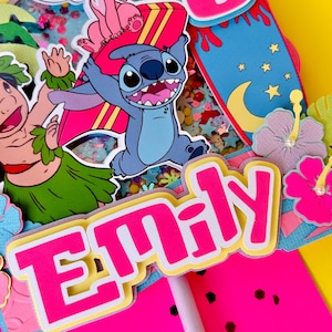 K&ouml;nnte beinhalten: Ein lebendiger Tortenaufsatz mit dem Namen "Emily" in leuchtendem Pink mit gelbem Rand. Er zeigt Cartoonfiguren, ein Surfbrett und die Zahl "6". Das Design hat ein tropisches Thema mit gelbem Hintergrund.