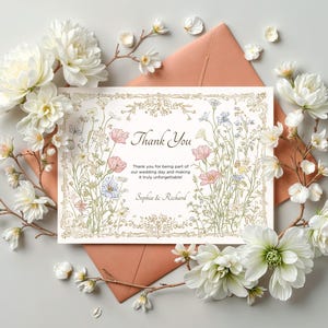 Elegant floral wedding invitation suite featuring pastel wildflowers and gold frame accents. Includes RSVP card, details card, welcome sign, thank you card, menu card, table number and main invitation with botanical illustrations on a soft ivory background. Romantic and vintage-inspired design, perfect for spring or boho weddings.