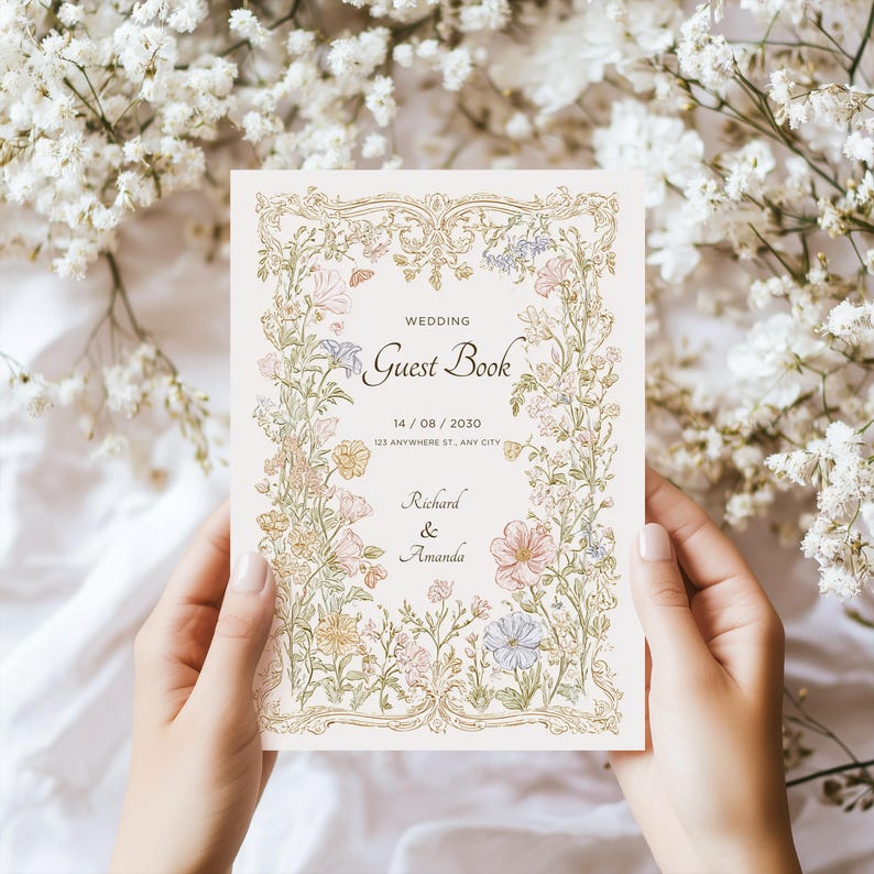 May include: A wedding guest book with floral illustrations in pastel colors. The cover features the words "Wedding Guest Book" and the names "Richard & Amanda". The date is displayed as 14/08/2030. The book is held by a person.