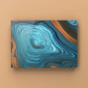 Peut inclure: Œuvre d'art abstraite avec un design fluide. L'œuvre présente des motifs tourbillonnants dans des tons de bleu, de sarcelle et de marron, créant un effet de superposition. La pièce est rectangulaire et montée sur un fond neutre.