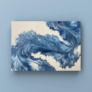 Op de afbeelding: Abstracte kunstprint met een wervelend ontwerp in blauwe en witte tinten. Het kunstwerk heeft een vloeiend, organisch uiterlijk, dat doet denken aan golven of veren. Het canvas is rechthoekig en gemonteerd op een lichtblauwe muur.