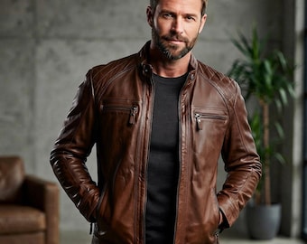 May include: A brown leather jacket featuring a stand-up collar, a full-length front zipper, and two zippered chest pockets. The shoulders and upper sleeves are detailed with a quilted diamond pattern, and the jacket is worn over a dark shirt.