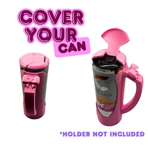 Può includere: Porta lattina rosa con manico e design a fiocco. Il supporto è progettato per adattarsi attorno a una lattina, con un coperchio che si apre. Il testo "COVER YOUR CAN" è visualizzato sopra il supporto. Il testo "*HOLDER NOT INCLUDED" è visualizzato sotto.