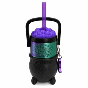 May include: A black cauldron-shaped tumbler with a glittery finish, featuring a metallic green and purple band embossed with the text Witches Brew. It includes a purple lid with bubble textures, a purple straw, a black handle, and a purple charm.