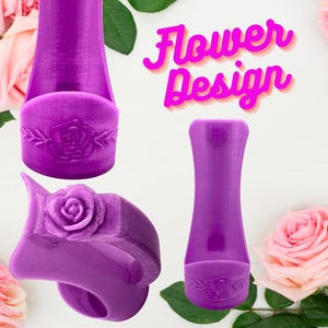 Op de afbeelding: Paarse accessoires met een bloemmotief. De afbeelding toont verschillende paarse accessoires met een rozenontwerp. De tekst "Flower Design" is roze met een gele omlijning. De accessoires omvatten een ring en een flesvormig item.