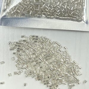Perline di semi a forma di tubo di tromba in argento di alta qualità, da 2 mm di lunghezza.