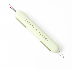 May include: A pale green seam ripper with the text "THREAD A NEEDLE" printed on the side. It features a silver blade with a red tip and a thread puller. This tool is designed for sewing and crafting projects, ideal for removing stitches.