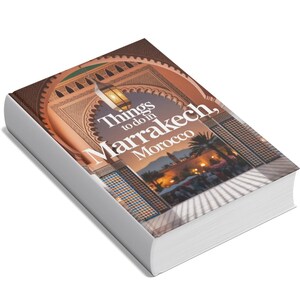 Puede incluir: Una guía de viaje titulada "Things to do in Marrakech, Morocco". La portada presenta un arco con diseños intrincados, una linterna colgante y una vista de una plaza concurrida. El libro tiene un lomo blanco y una gruesa pila de páginas.
