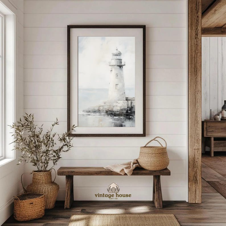 A grouped display of coastal printable wall art with several framed seaside images, including a lighthouse on rocky shore, a sailboat on still water, a sunset harbor scene, a coastal village by the sea, and a text-based nautical design reading Salt Air Adventure. The artwork uses gentle blue, cream, and soft golden tones with watercolor-style detail, creating a classic coastal grandmother mood with elegant nautical imagery and a calm, collected printable bundle look.