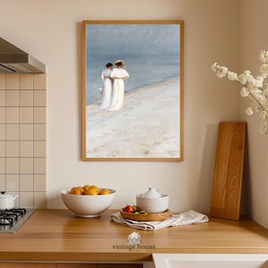 A grouped display of coastal printable wall art with several framed seaside images, including a lighthouse on rocky shore, a sailboat on still water, a sunset harbor scene, a coastal village by the sea, and a text-based nautical design reading Salt Air Adventure. The artwork uses gentle blue, cream, and soft golden tones with watercolor-style detail, creating a classic coastal grandmother mood with elegant nautical imagery and a calm, collected printable bundle look.