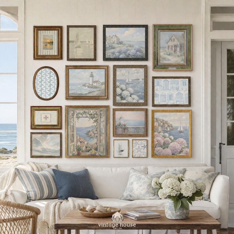 A large coastal gallery wall bundle showing a coordinated mix of seaside printable artworks, including sailboat paintings, a hydrangea-covered coastal cottage, lighthouse art, floral ocean scenes, a window view over the sea, soft sky studies, nautical map-style motifs, and striped coastal patterns. The collection uses muted blue, white, beige, and weathered neutral tones to create a refined coastal grandmother aesthetic with vintage-inspired charm and layered printable wall art variety.