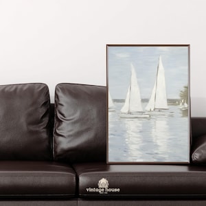 A grouped display of coastal printable wall art with several framed seaside images, including a lighthouse on rocky shore, a sailboat on still water, a sunset harbor scene, a coastal village by the sea, and a text-based nautical design reading Salt Air Adventure. The artwork uses gentle blue, cream, and soft golden tones with watercolor-style detail, creating a classic coastal grandmother mood with elegant nautical imagery and a calm, collected printable bundle look.