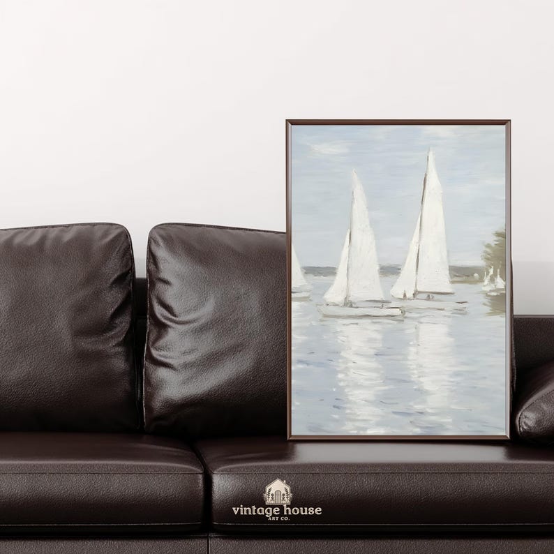 A grouped display of coastal printable wall art with several framed seaside images, including a lighthouse on rocky shore, a sailboat on still water, a sunset harbor scene, a coastal village by the sea, and a text-based nautical design reading Salt Air Adventure. The artwork uses gentle blue, cream, and soft golden tones with watercolor-style detail, creating a classic coastal grandmother mood with elegant nautical imagery and a calm, collected printable bundle look.