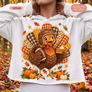 Könnte beinhalten: Ein weißer Kapuzenpullover mit langen Ärmeln und einer Grafik eines braunen Truthahns, der einen braunen Football-Helm aus Leder trägt. Der Truthahn hält einen Football und ein Stück Kürbiskuchen. Die Schwanzfedern zeigen verschiedene Muster.