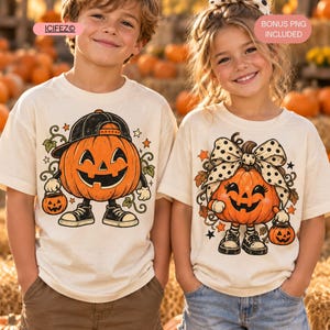 Może przedstawiać: Dwie koszulki w kolorze złamanej bieli z grafikami na Halloween. Lewa koszulka przedstawia dynię w czapce z daszkiem i trampkach, trzymającą małe wiaderko. Prawa koszulka przedstawia dynię z kokardą w kropki i trampkach, trzymającą wiaderko.