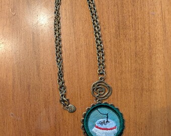 A 1960's Girl Scout need point badge necklace