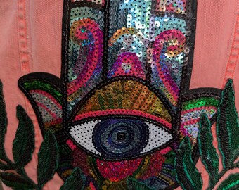 Un chaleco reciclado de color mandarina con Hamsa de diamantes de imitación