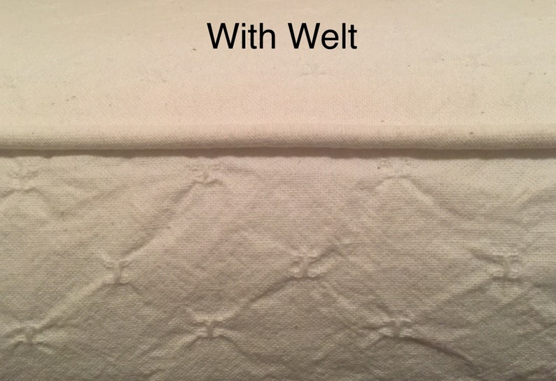 May include: Close-up of a white fabric with a welt seam. The fabric has a quilted pattern with diamond shapes.