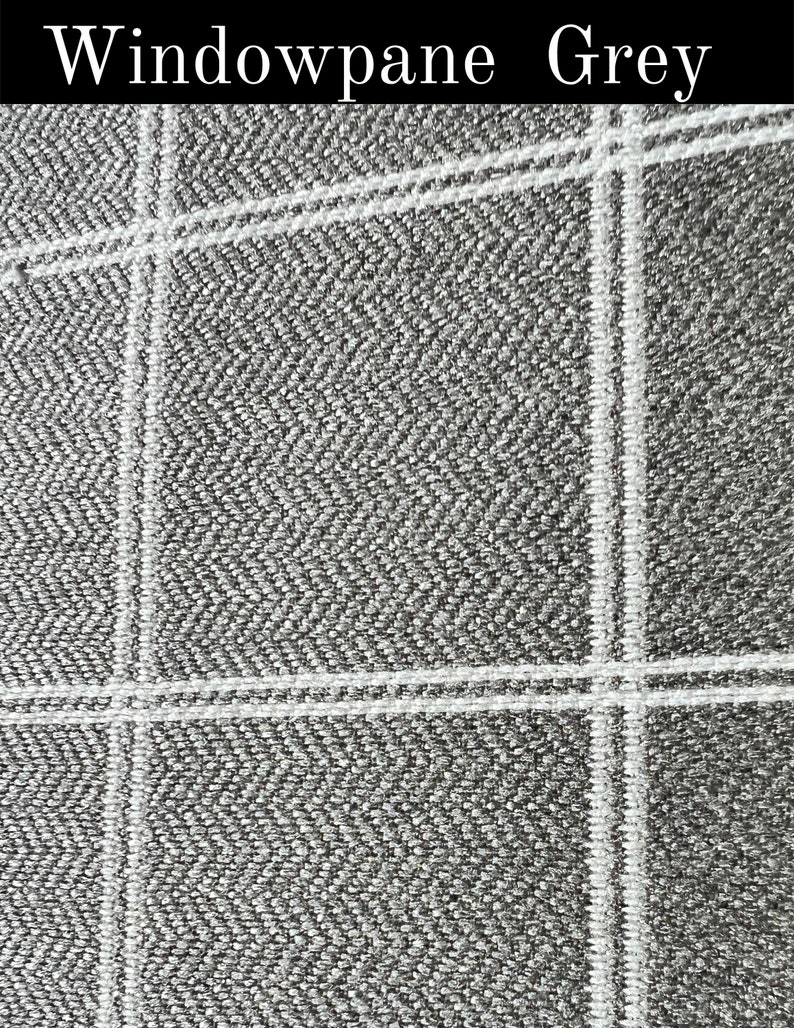May include: A close-up of a grey fabric with a white windowpane pattern. The fabric has a textured weave.