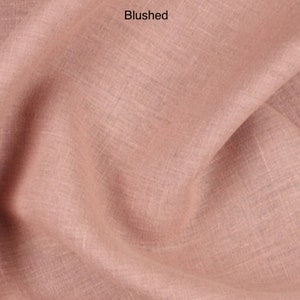 Puede incluir: Primer plano de una tela suave y texturizada de color rosa claro. La tela tiene un brillo sutil y una apariencia ligeramente arrugada. La palabra "Blushed" est&aacute; escrita en blanco en la parte superior de la imagen.