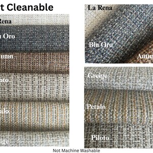 May include: A collection of fabric swatches in various colors, including gray, blue, and brown. The swatches are labeled with names like "La Rena," "Blu Oro," and "Autumn." The text "Spot Cleanable" and "Not Machine Washable" are also visible.