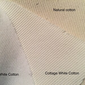 May include: Close-up of three cotton fabric samples. The samples are labelled "White Cotton", "Cottage White Cotton", and "Natural cotton". The fabrics display varying textures and shades of white and off-white.