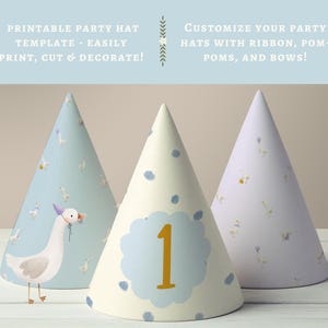 May include: Three printable party hats with a blue and white goose pattern. The center hat has a blue circle with the number "1" in gold. The text "PRINTABLE PARTY HAT TEMPLATE - EASILY PRINT, CUT & DECORATE!" is at the top of the image. The text "CUSTOMIZE YOUR PARTY HATS WITH RIBBON, POM-POMS, AND BOWS!" is at the top right of the image.
