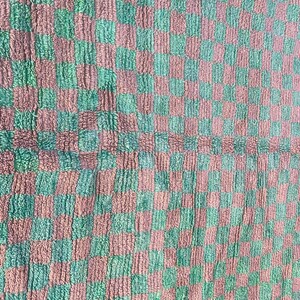 May include: A checkered fabric with a green and pink pattern. The fabric has a fuzzy texture.