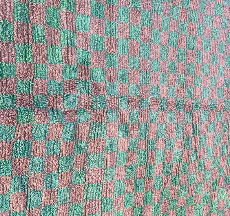 May include: A checkered fabric with a green and pink pattern. The fabric has a fuzzy texture.