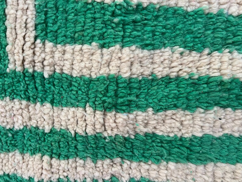 Pode incluir: Close-up de um tapete texturizado com listras verdes e branco-sujo alternadas. O tapete tem uma pilha espessa e macia, e as cores s&atilde;o vibrantes. O design &eacute; simples e moderno, adequado para decora&ccedil;&atilde;o de casa.