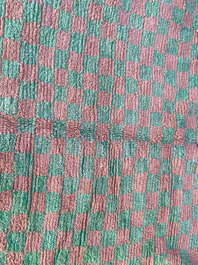 May include: A checkered fabric with alternating squares of green and brown. The fabric has a fuzzy texture.