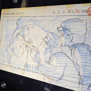 May include: A black and white pencil sketch of three characters from a Japanese animated film. The characters are drawn in a style reminiscent of Studio Ghibli. The sketch is on a white background with blue lines.