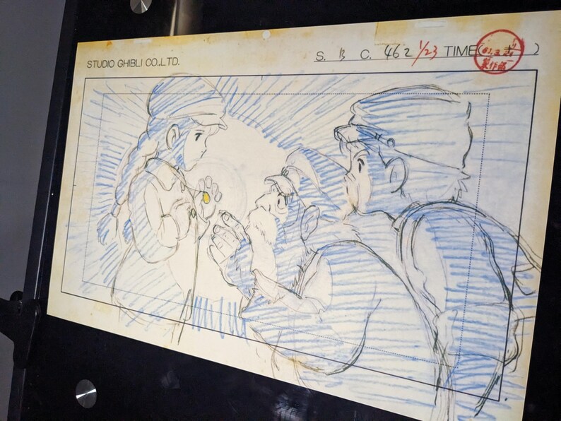 May include: A black and white pencil sketch of three characters from a Japanese animated film. The characters are drawn in a style reminiscent of Studio Ghibli. The sketch is on a white background with blue lines.