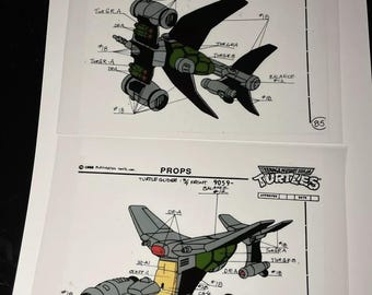 May include: A black and green cartoon spaceship with the text "TURTLE GLIDER: 1/2 BOTTOM, REAR 9059- BALANCE #12" and "TURTLES" on the page. The spaceship has a green cockpit and multiple wings and propellers.