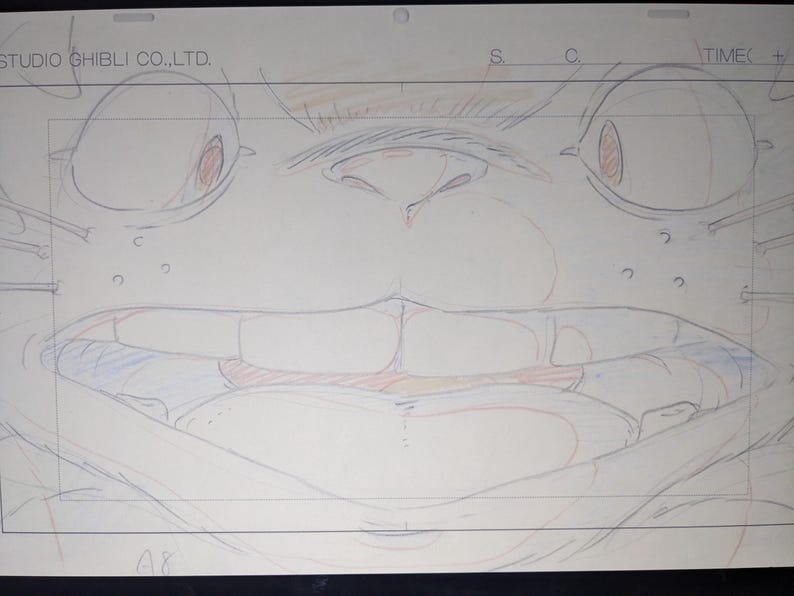 May include: A close-up drawing of a cartoon character's face. The character has large eyes, a wide mouth, and a large nose. The drawing is done in pencil and colored pencil on a white sheet of paper. The text "STUDIO GHIBLI CO., LTD." is visible at the top of the page.