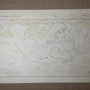 May include: Original animation cel from Studio Ghibli featuring a character with a sword, lying on the ground. The cel is hand-drawn with pencil and colored with light tones. The text "STUDIO GHIBLI CO., LTD." is visible.