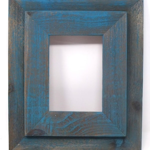 May include: A rustic wooden picture frame with a double layer of blue paint. The frame has a distressed look with visible wood grain.