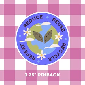 Puede incluir: Un botón redondo con borde azul muestra las palabras "Reduce, Reuse, Recycle, Repeat" alrededor de un gráfico de la Tierra con hojas, nubes y flores. El botón mide 3,18 cm de diámetro y está sobre un fondo a cuadros rosa y blanco.
