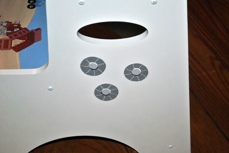 Pu&ograve; includere: Struttura di gioco in legno bianco per bambini con tre cerchi dipinti di grigio con un motivo a spirale.