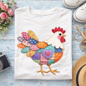Puede incluir: Camiseta blanca con un diseño de gallina de retazos coloridos. La gallina tiene una cresta roja, una carúncula rosa y un parche en forma de corazón. El diseño incorpora varios patrones y colores, incluyendo lunares, estampados florales y cuadros.