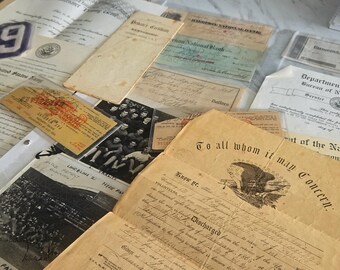 Puede incluir: Una colección de documentos de papel antiguos, que incluye un certificado del Department of the Navy Bureau of Naval Personnel, un documento de baja con un emblema de águila que dice To all whom it may concern, cheques bancarios y fotografías en blanco y negro.