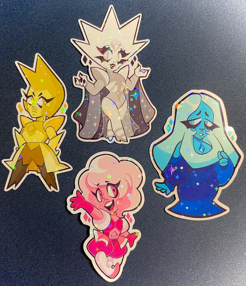 May include: Four holographic stickers featuring cartoon characters. The characters include a yellow figure, a white figure with a cape, a pink figure, and a blue figure. Each sticker has a unique design and pose, with a sparkly, iridescent finish.