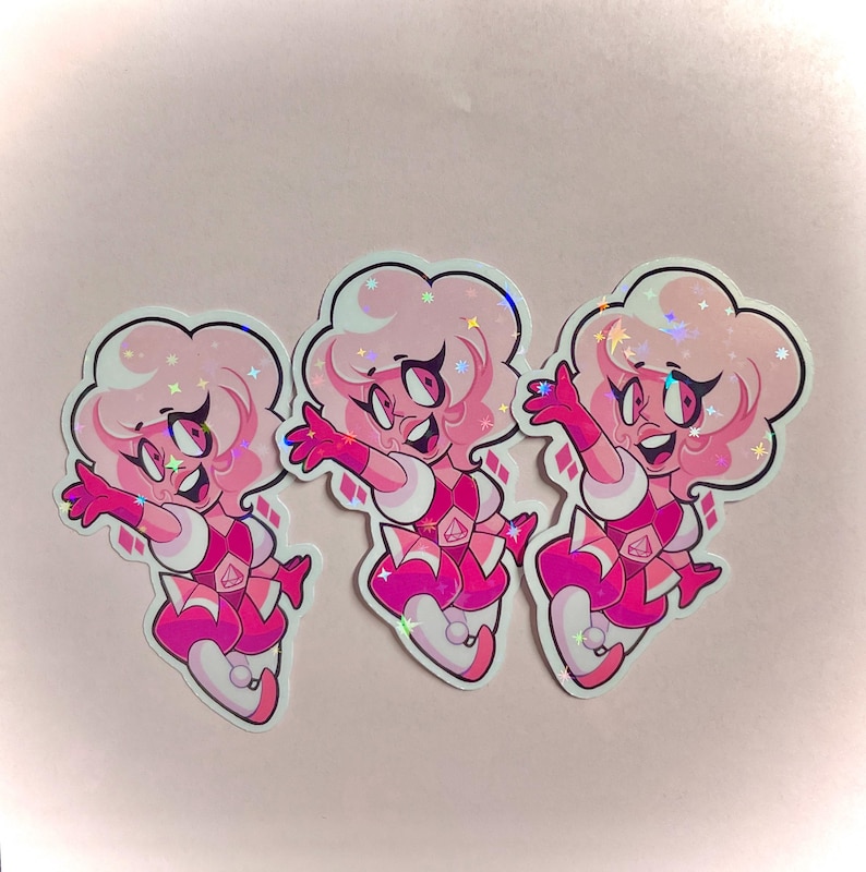 May include: Three stickers featuring a cartoon character with pink skin, hair, and clothing. The character has a joyful expression with arms outstretched. The stickers have a holographic, iridescent finish and a white border. The background is a light pink.
