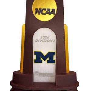 May include: A white ceramic mug with a black handle and the text "But First, Coffee" in a bold, black font. The mug is filled with a dark liquid, likely coffee, and sits on a light-colored surface.