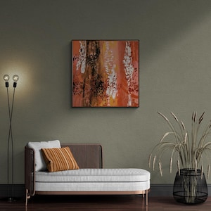 Puede incluir: Pintura abstracta con colores naranja, marrón, negro y blanco. La pintura está enmarcada y colgada en una pared verde.