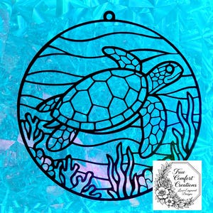 May include: Black sea turtle design in a circular frame with a loop for hanging. The turtle is swimming in a blue ocean with seaweed and coral. The background is a textured, light blue color. The design includes the text "True Comfort Creations, Laser Engraved Designs."