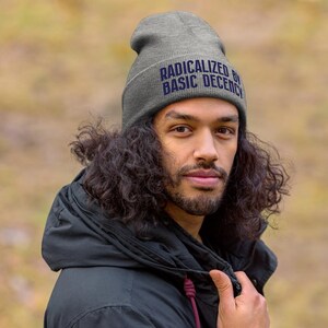 May include: A gray beanie with the text "Radicalized by Basic Decency" in blue lettering.